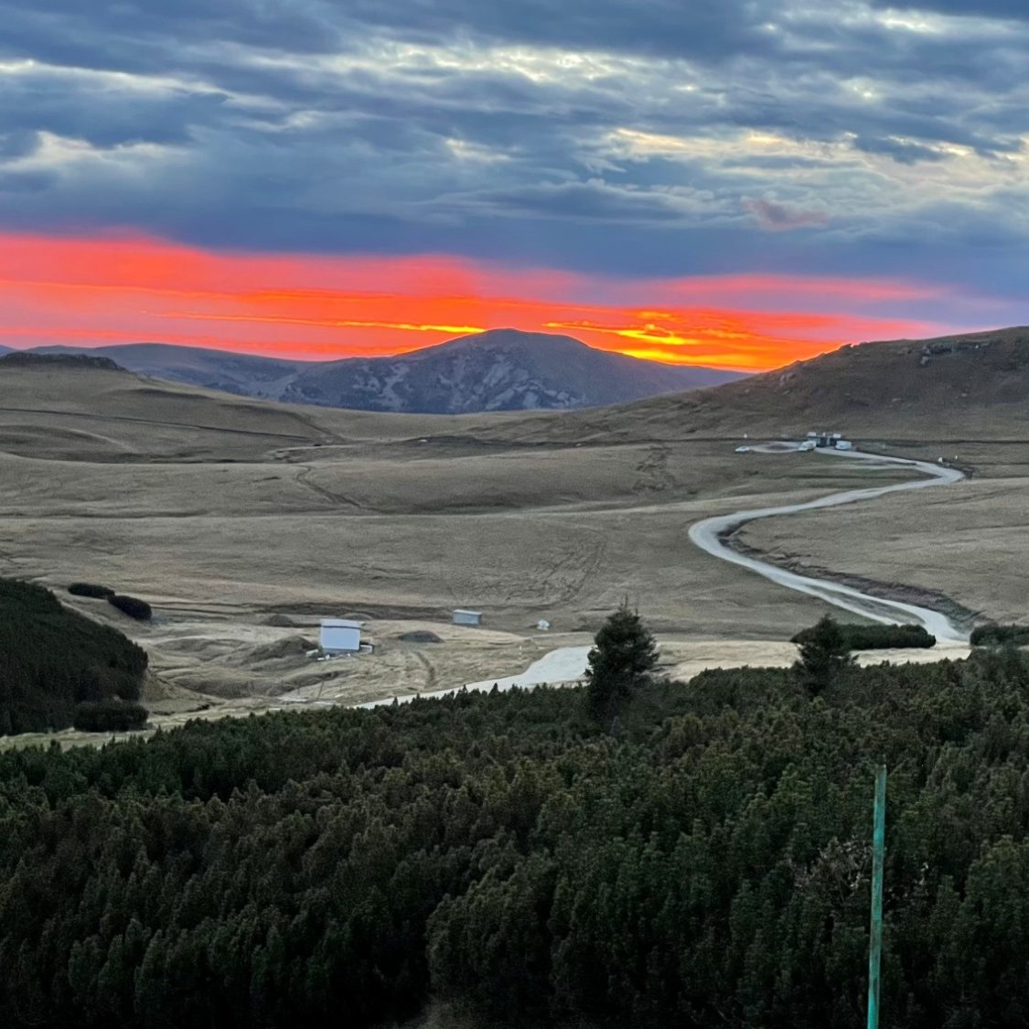 Kurvige Landstraße bei Sonnenuntergang in den Bergen